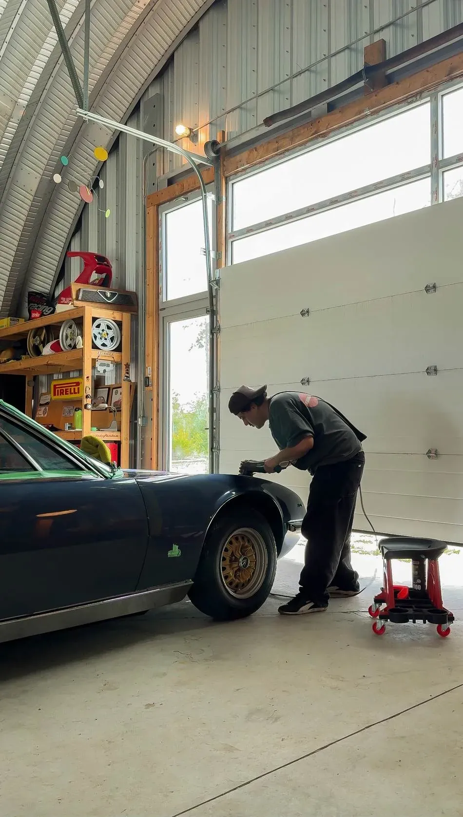 Johnnie hand-polishing a classic car in the garage