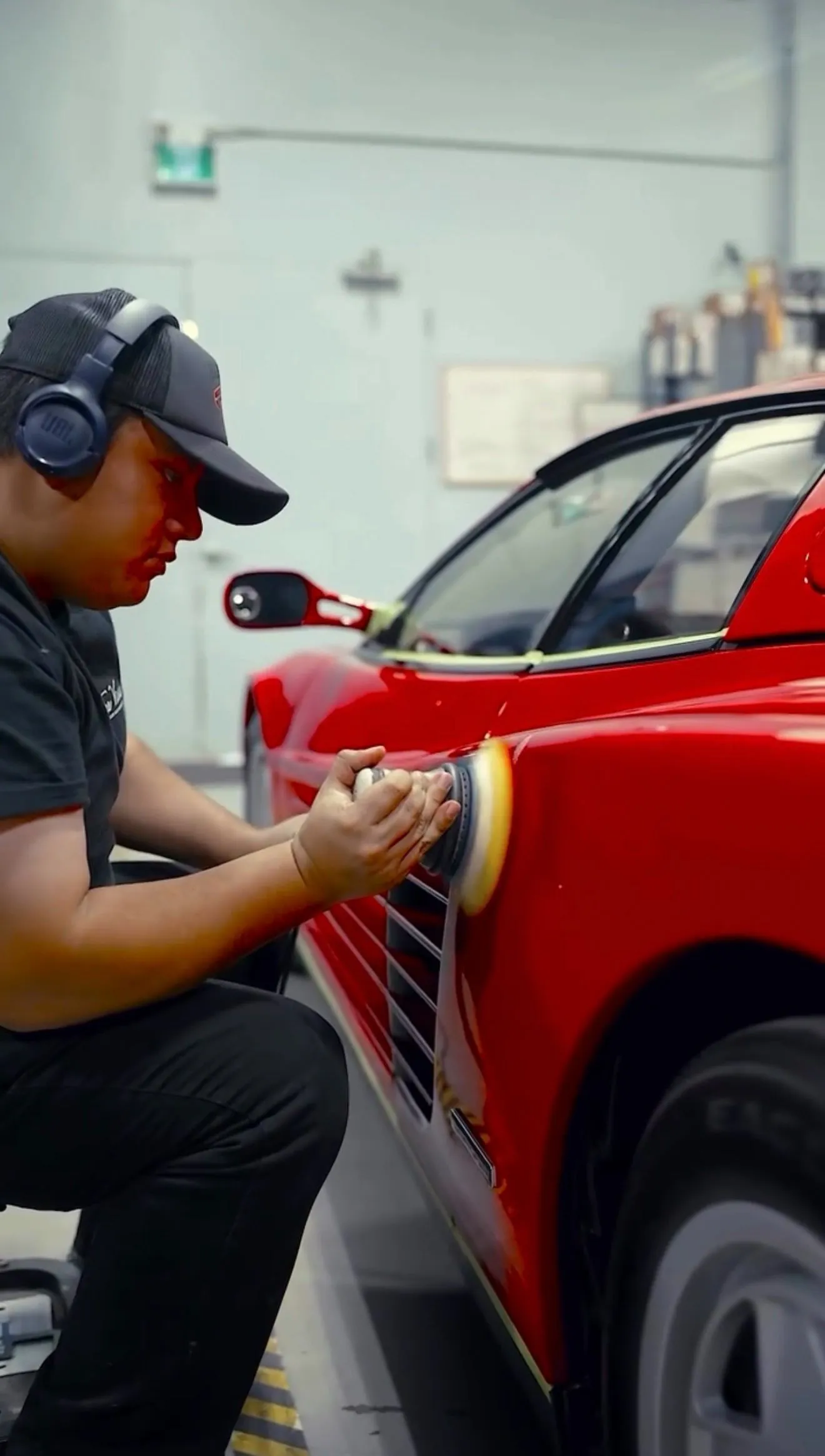 Machine-polishing a red Ferrari panel